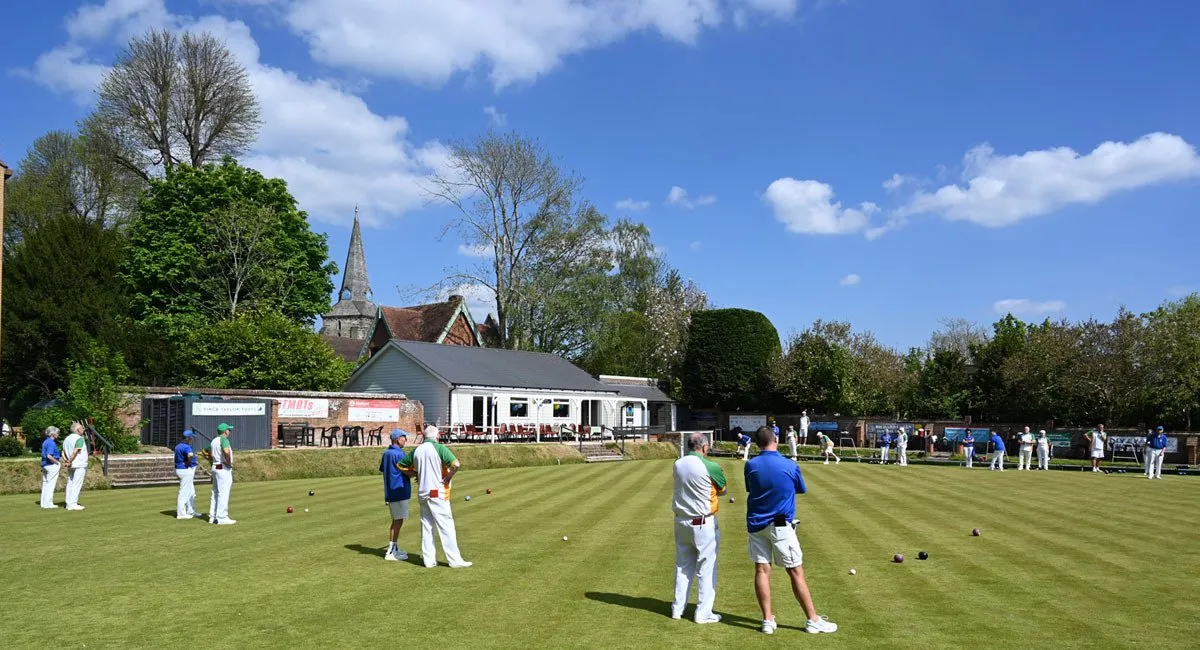 A wide angle photo of the club house, green and garden surrounds